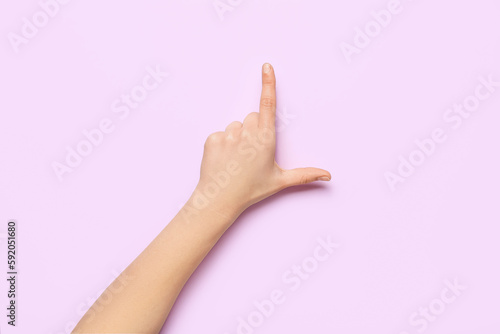 Woman showing loser gesture on lilac background © Pixel-Shot