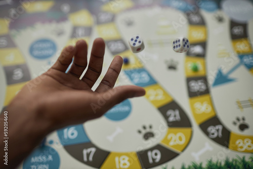 Close up of black male hand throwing dice making a move in board game, copy space