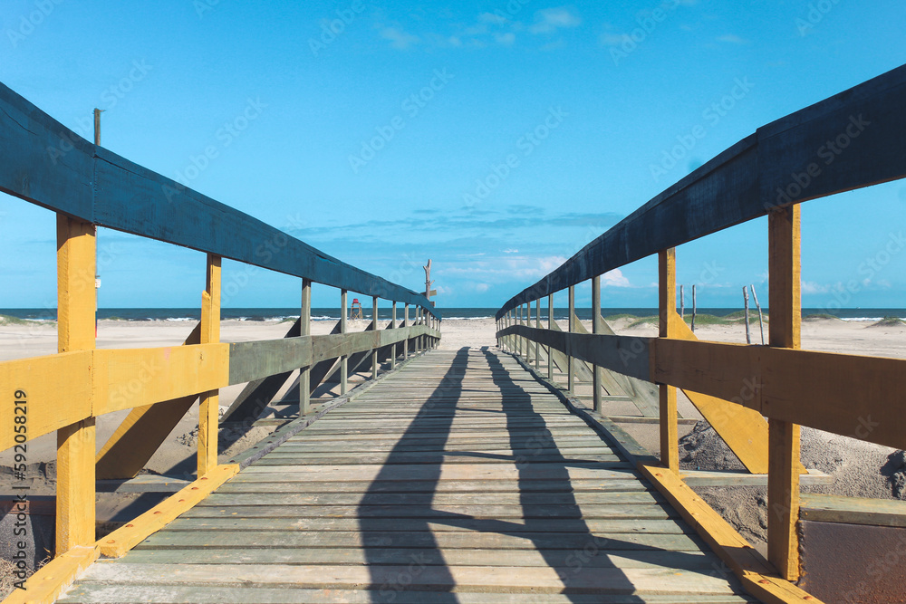 wooden bridge on the beach on Ilha Comprida beach, south coast of São Paulo, Brazil.
