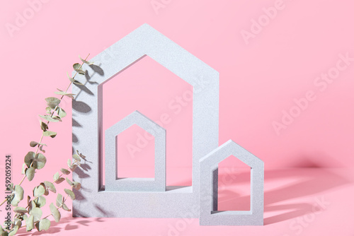 Decorative house shaped frames with eucalyptus branches on pink background