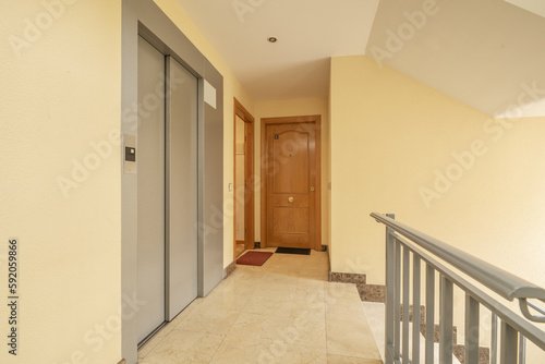 Building landing with stairs  cream marble floor and elevator access with gray metal door