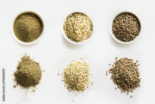 Hemp as seeds, flour, kernels in piles and bowls isolated on white background. View from above. Organic ingredient for cooking vegan and healthy food.