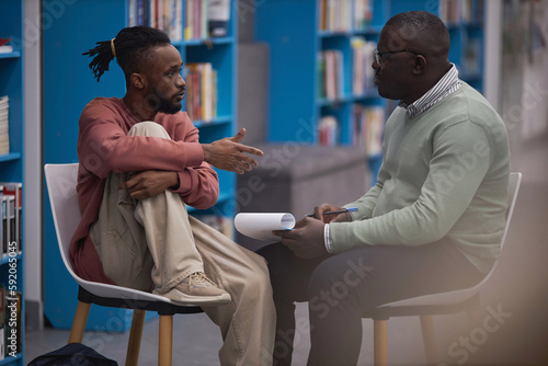 Foto Side view portrait of black student talking to mental health therapist or guidan