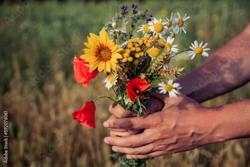 person holding meadow flowers