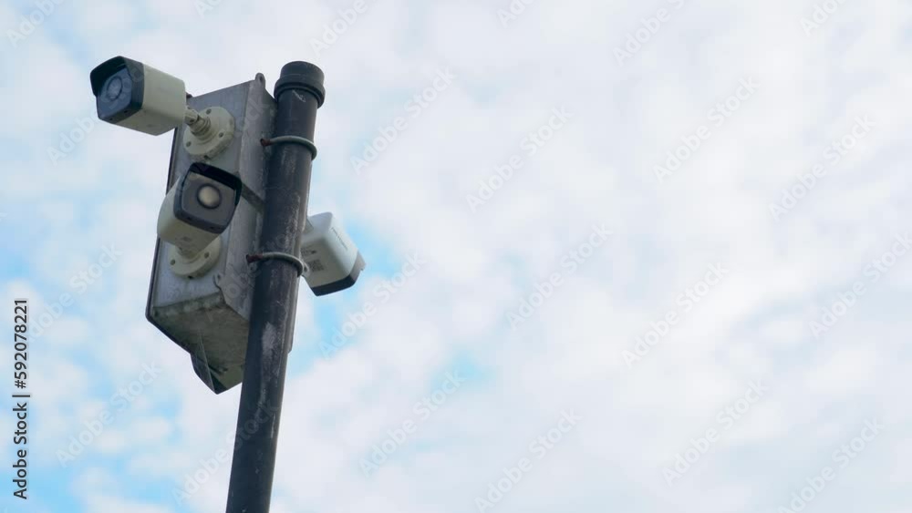 Security Cameras on a Pole with Clouds in the Background Security Cameras on a Pole with Clouds in the Background