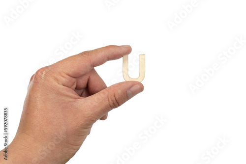 Unrecognizable person holding a letter u on a white background