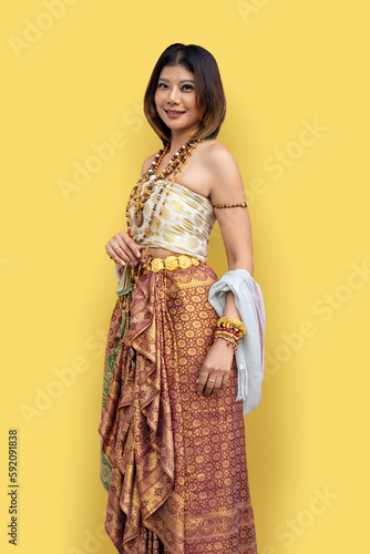 Portrait of Thai woman wearing Thai traditional dress on light yellow background.