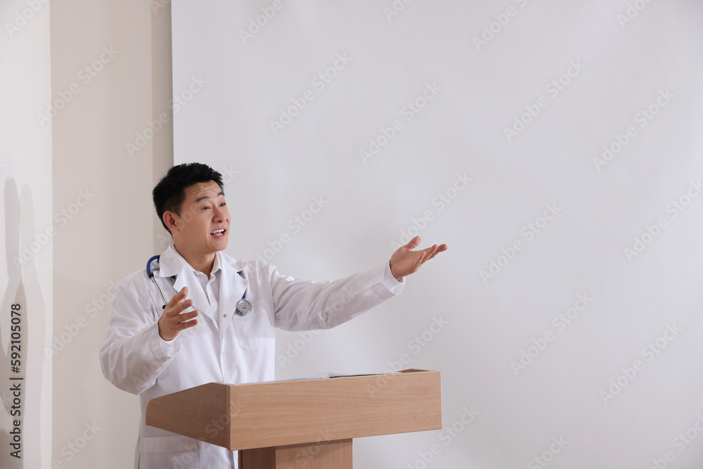 Doctor giving lecture in conference room with projection screen Doctor giving lecture in conference room with projection screen