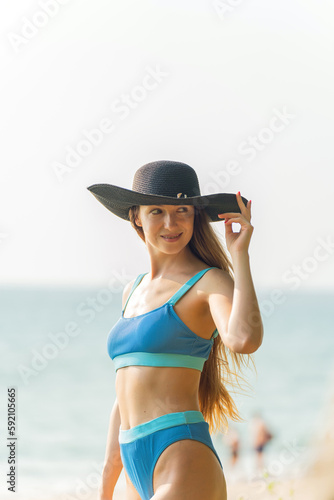 Beautiful woman in bikini on the beach enjoying her holiday and sea breeze