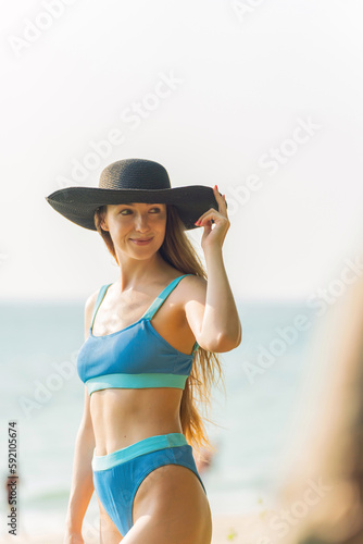 Beautiful woman in bikini on the beach enjoying her holiday and sea breeze