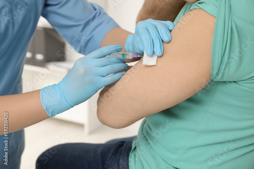 Doctor giving hepatitis vaccine to patient in clinic  closeup
