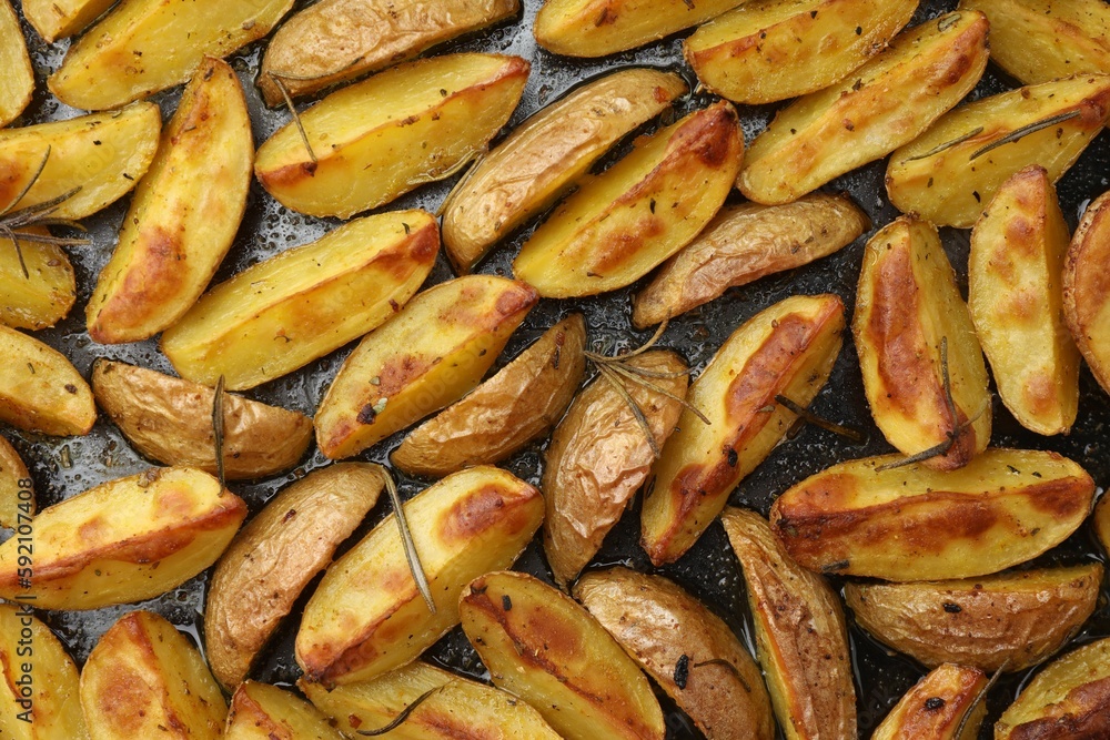 Delicious baked potatoes with rosemary on black surface, flat lay Delicious baked potatoes with rosemary on black surface, flat lay