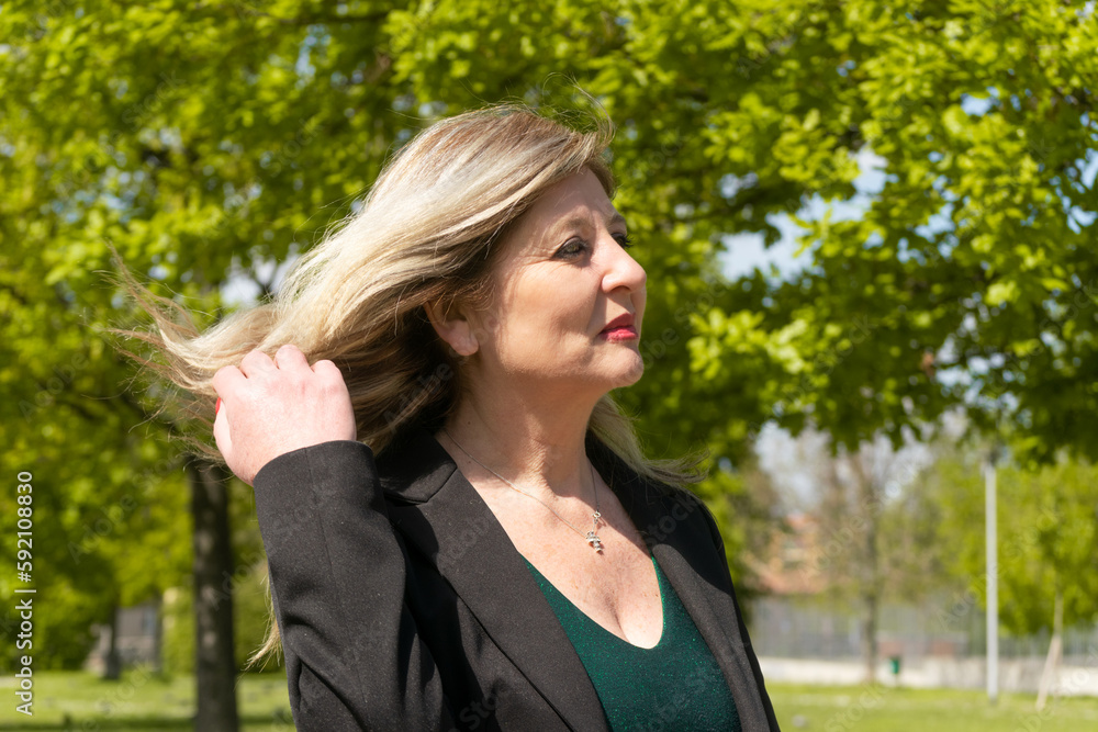 Happy mature blonde woman walking on the park Happy mature blonde woman walking on the park