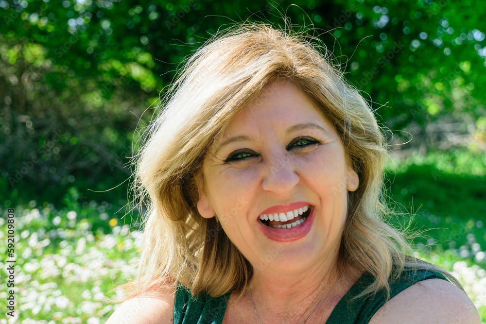 Mature happy woman in the in grass with marguerites. Menopause and mother's day concept Mature happy woman in the in grass with marguerites. Menopause and mother's day concept