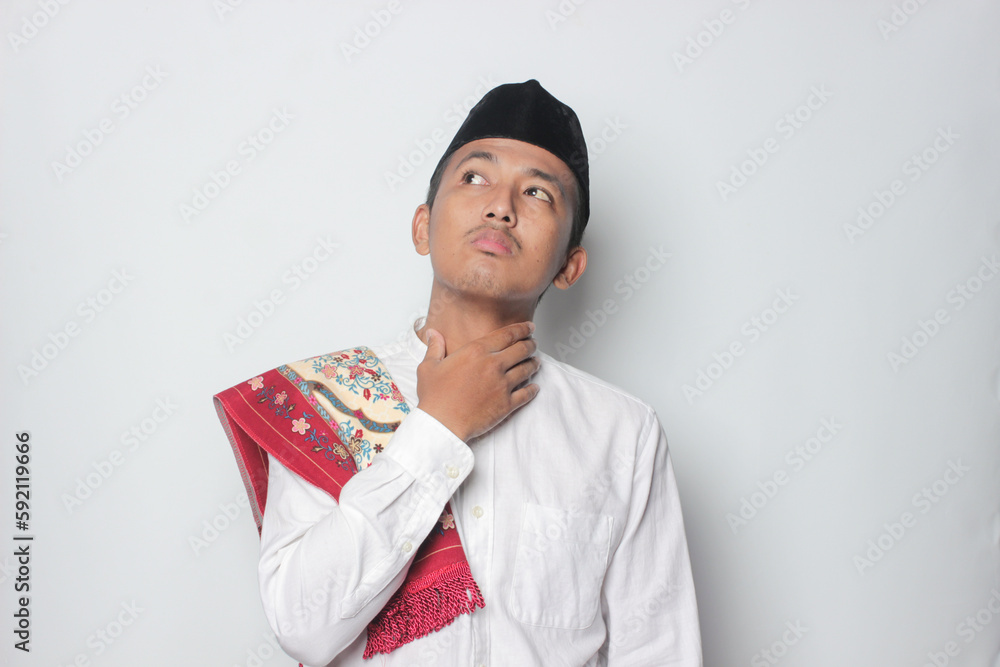 An Asian Muslim man wearing white shirt feels so hungry and thirsty because of the hot weather during the summer season while fasting ramadhan. An Asian Muslim man wearing white shirt feels so hungry and thirsty because of the hot weather during the summer season while fasting ramadhan.