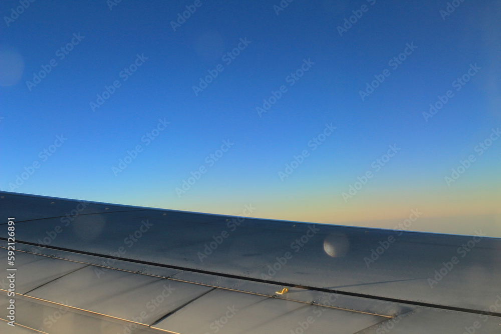 Fototapeta premium sky from the plane, plane wing, sunset time