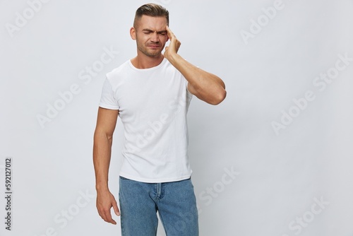 Man headache, migraine, high fever, in white T-shirt on white isolated background, copy space