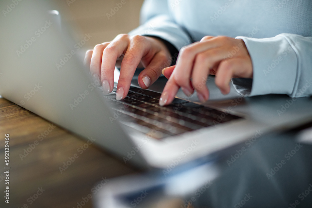 Young adult woman working on her laptop in the kitchen of her home Young adult woman working on her laptop in the kitchen of her home