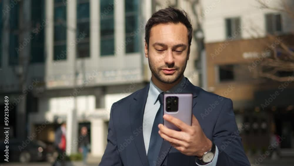 Cheerful Bearded Business Man Using Phone and Eating Wholegrain Donut Commuting to Office in Urban Background Cheerful Bearded Business Man Using Phone and Eating Wholegrain Donut Commuting to Office in Urban Background