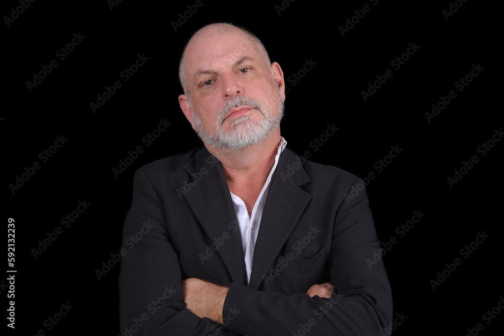 Handsome middle-aged man in a suit posing against black background. confident business man
