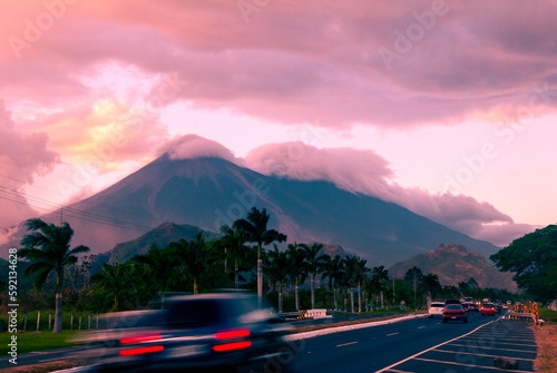 Palin Escuitla highway at sunset in Guatemala, Central America, passenger and cargo transport area, cloud covered volcanoes in the background. photo
