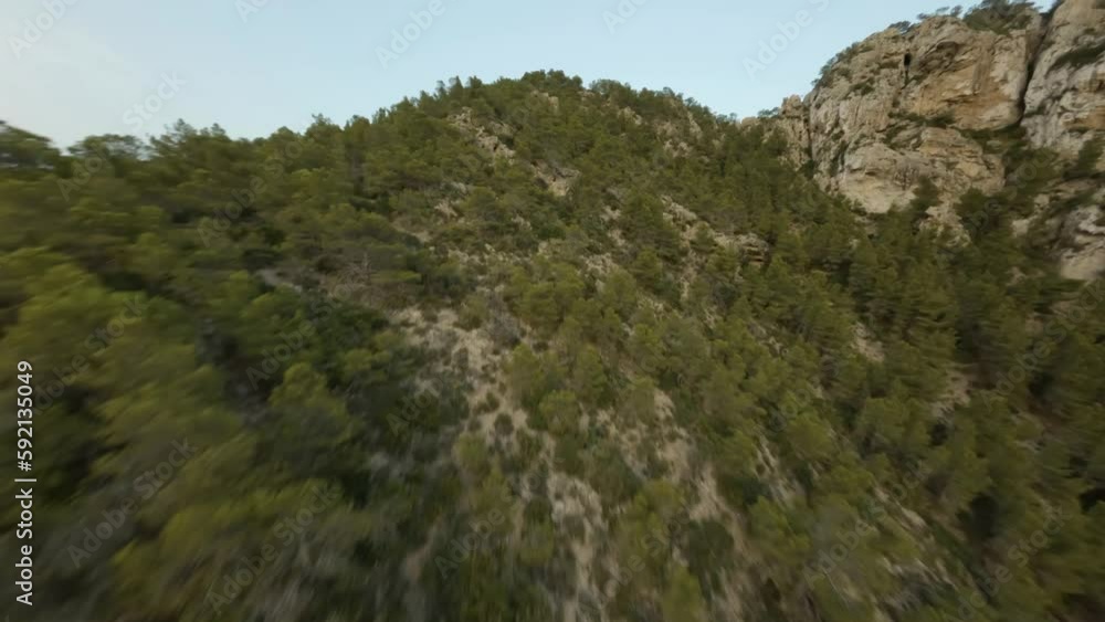 Fpv Drone view of cliffs and sailboats docked along seaside in Cala d'egos beach Fpv Drone view of cliffs and sailboats docked along seaside in Cala d'egos beach