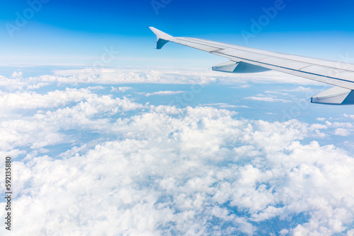 View from the airplane window at a beautiful cloudy sky and the airplane wing