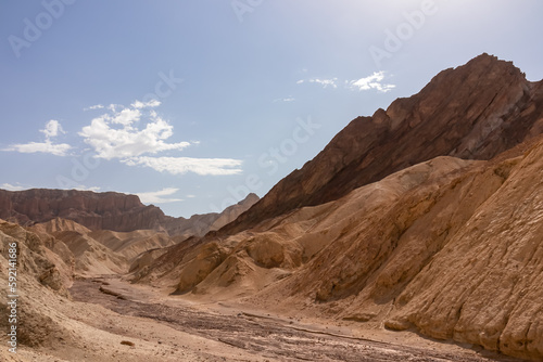 Golden Canyon trailhead with scenic view of colorful geology of multi hued Amargosa Chaos rock formations, Death Valley National Park, Furnace Creek, California, USA. Barren Artist Palette landscape © Chris