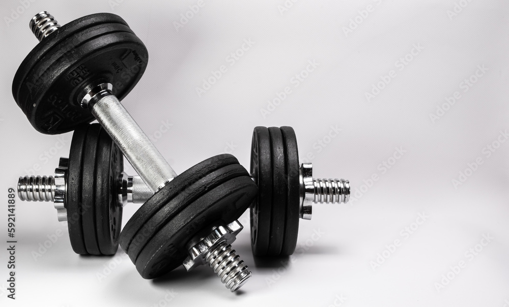 Naklejka premium Metal dumbbells with black pancakes on a white background.