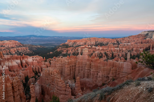 Aerial sunset view of massive hoodoo sandstone rock formation boat mesa in Bryce Canyon National Park, Utah, USA. Last sun rays touching on natural unique amphitheatre sculpted from red rock. Twilight