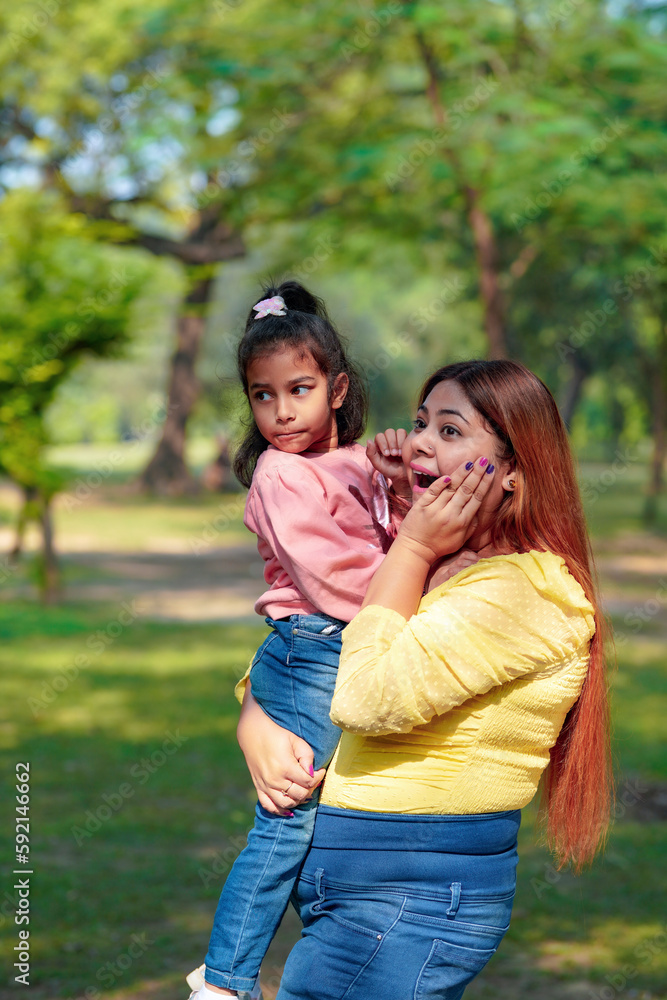 Indian woman with her little daughter at park Indian woman with her little daughter at park