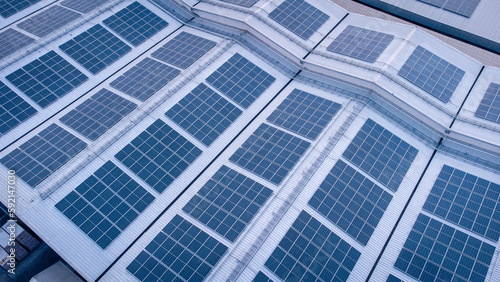 A large solar cell roof on an industrial building Generating electricity for the plant during daytime according to policies and measures to reduce global warming by taking high-angle shots from drones