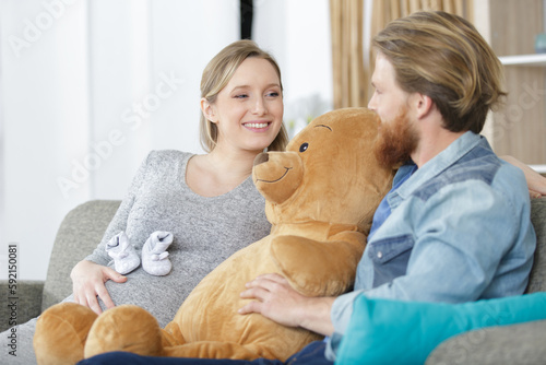 young couple sat with giant teddy bear