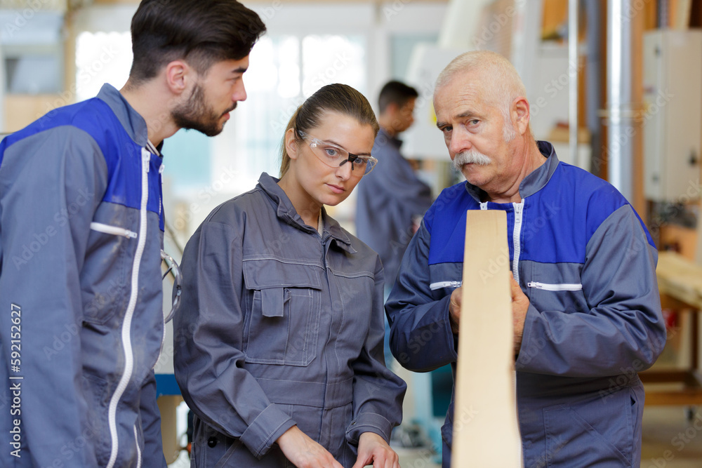 Obraz premium woodworker trainer teaching how to inspect evenness