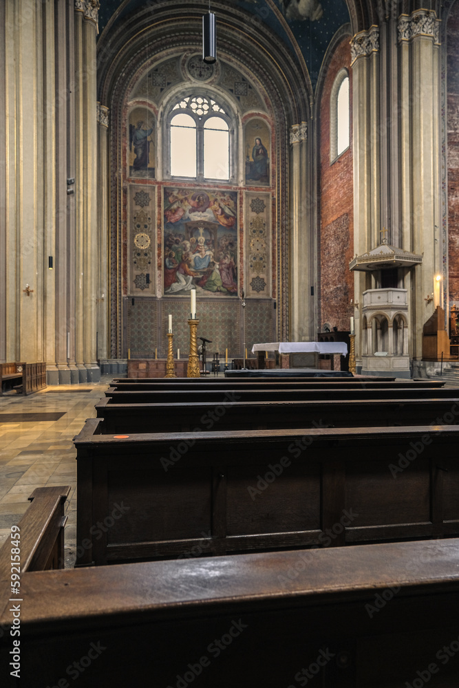 Fototapeta premium Monumental church building in Gothic in neo-romanesque arch style with large ceiling and altar murals and fresco, opulent detailed columns and marble structures