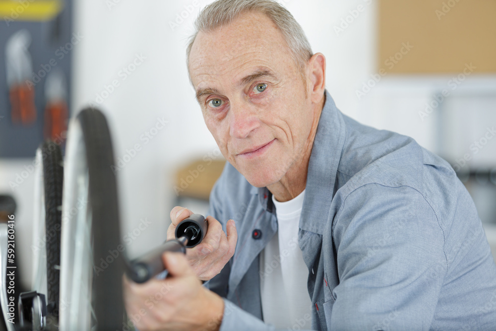 senior man pumping a bicycle tire