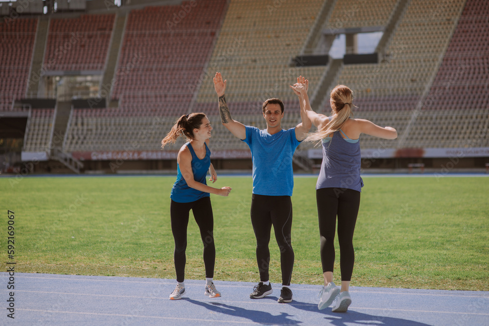 Happy male sportsperson giving high five to his female friends