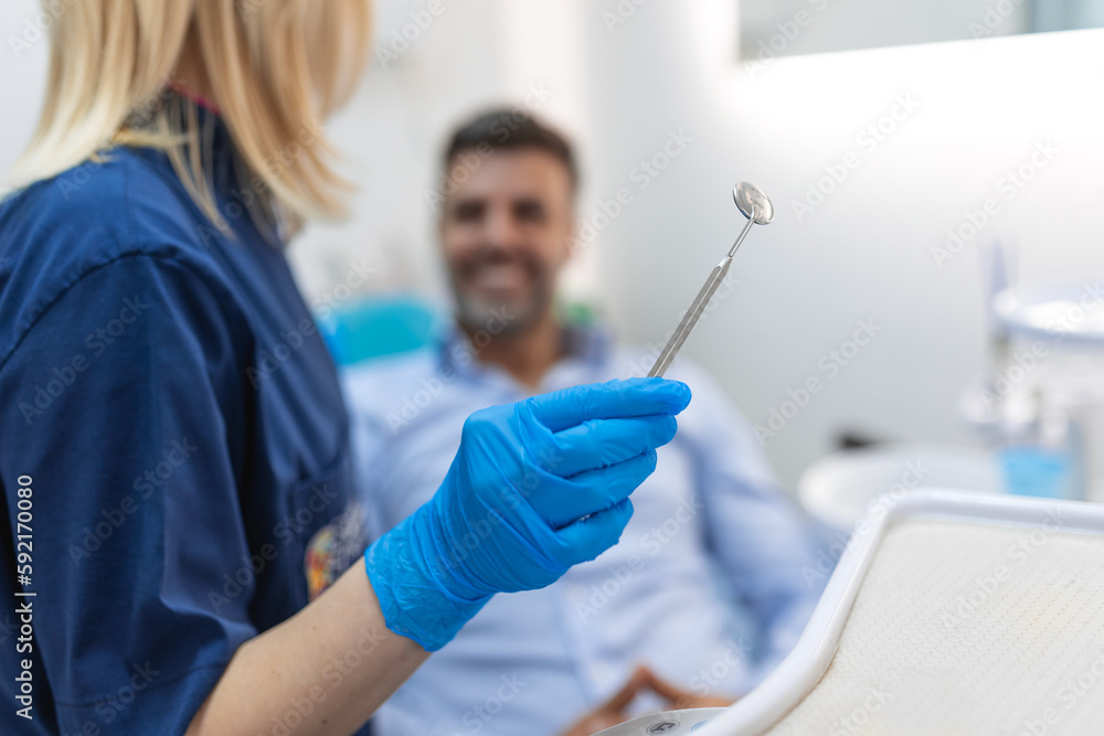 Image of satisfied man sitting in dental chair at medical center while professional doctor fixing his teeth Image of satisfied man sitting in dental chair at medical center while professional doctor fixing his teeth