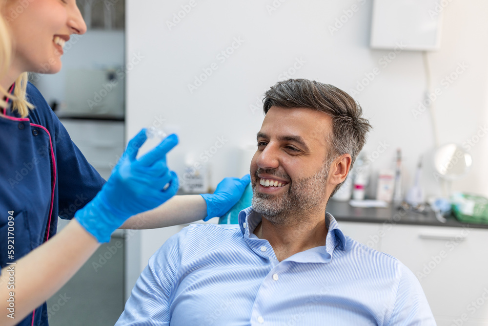 A young female dentist showing invisalign to patient in dental clinic, teeth check-up and Healthy teeth concept A young female dentist showing invisalign to patient in dental clinic, teeth check-up and Healthy teeth concept
