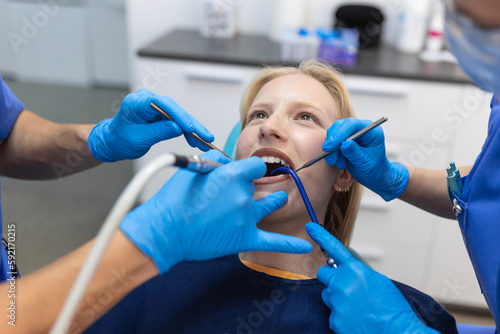 Teeth health concept. Cropped photo of smiling woman mouth under treatment at dental clinic