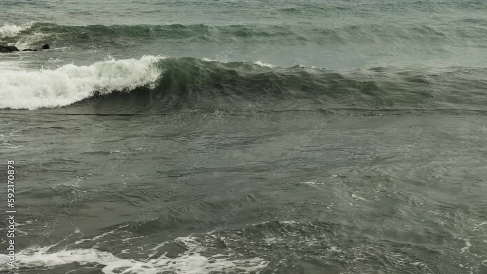 A mesmerising view of the stormy sea. Waves rise and roll up one after the other, leaving foam behind. A slow motion shot A mesmerising view of the stormy sea. Waves rise and roll up one after the other, leaving foam behind. A slow motion shot