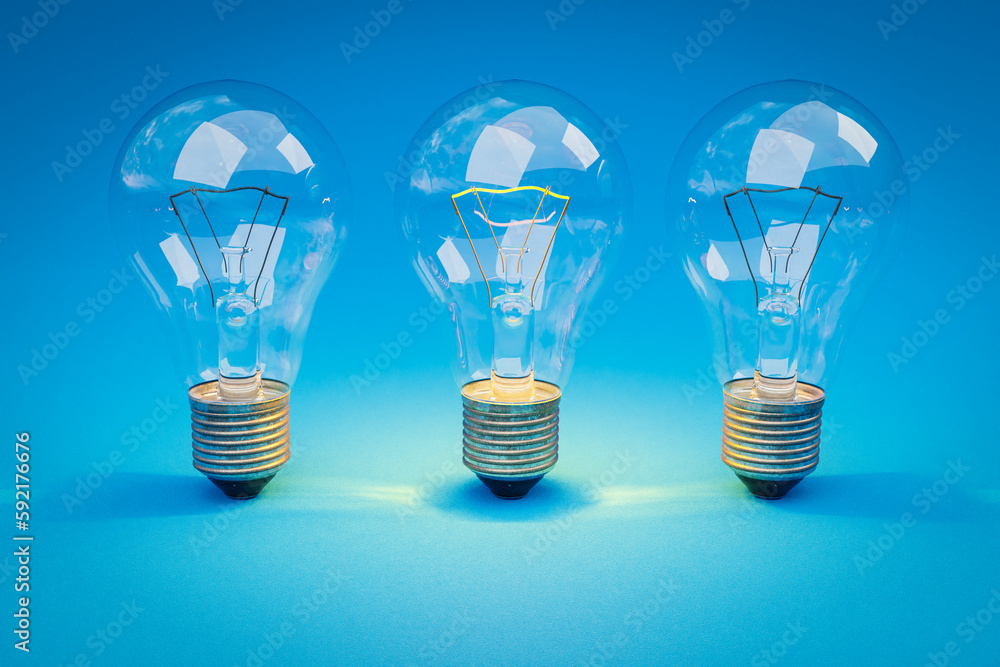 three retro style lightbulbs with glowing filament standing in a row on infinite colorful background; creativity design concept; 3D Illustration three retro style lightbulbs with glowing filament standing in a row on infinite colorful background; creativity design concept; 3D Illustration