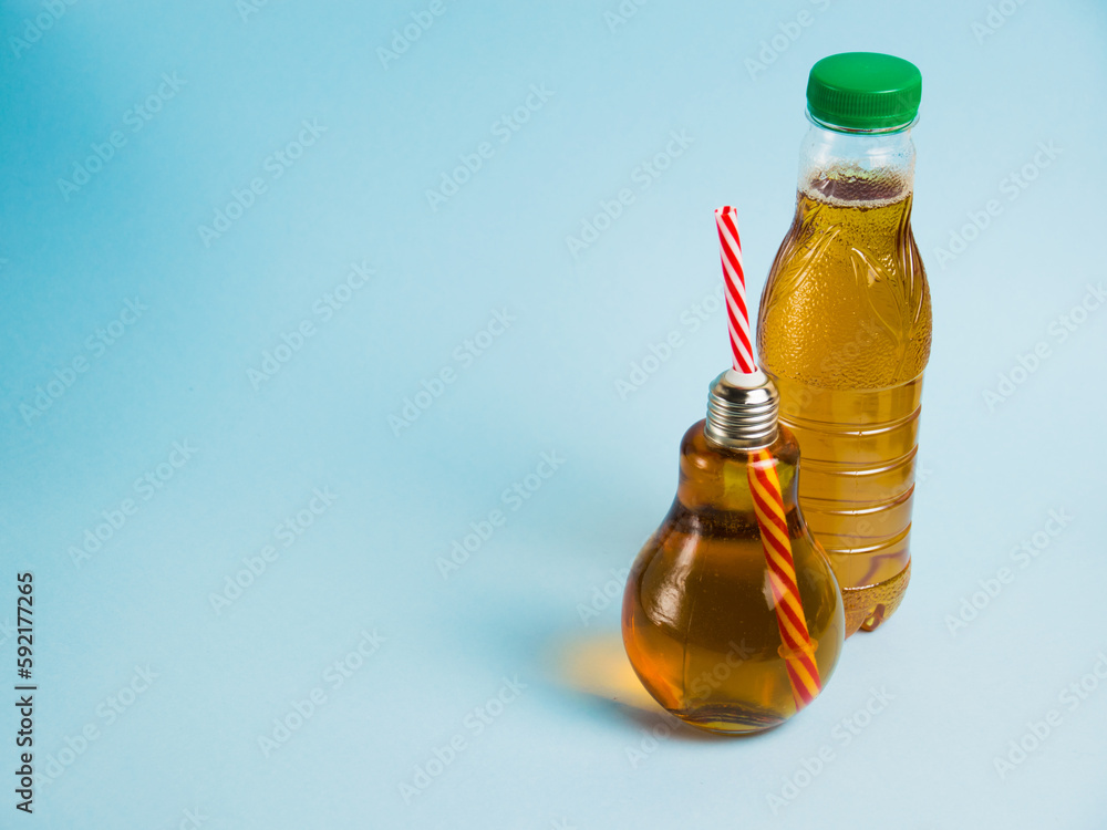 Juice in a plastic bottle and drink in a reusable glass bottle on a blue background. Concept of earth day, zero waste and plastic recycling. Juice in a plastic bottle and drink in a reusable glass bottle on a blue background. Concept of earth day, zero waste and plastic recycling.