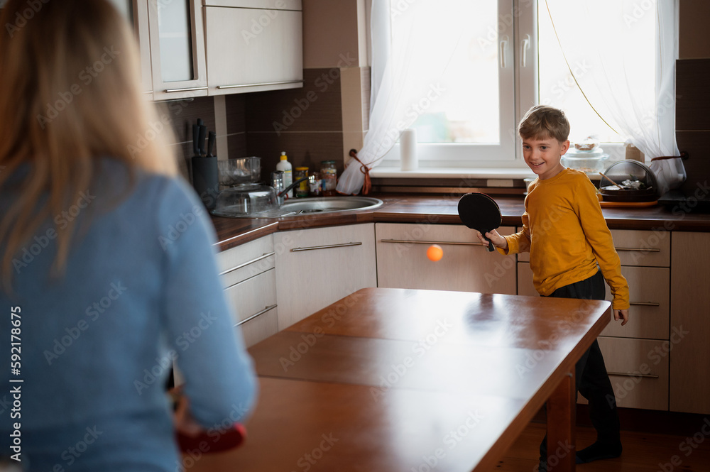 Young boy playing table tennis in the kitchen Young boy playing table tennis in the kitchen
