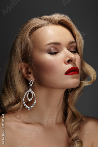 Beautiful Woman with Fashion Make-up and Blond Wave Hairstyle. Glamour American Diva Style with Brilliant Accessories