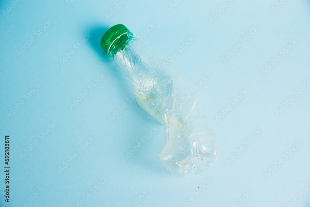Used plastic bottle of juice for a drink on a blue background. Concept of earth day, zero waste and plastic recycling. Used plastic bottle of juice for a drink on a blue background. Concept of earth day, zero waste and plastic recycling.