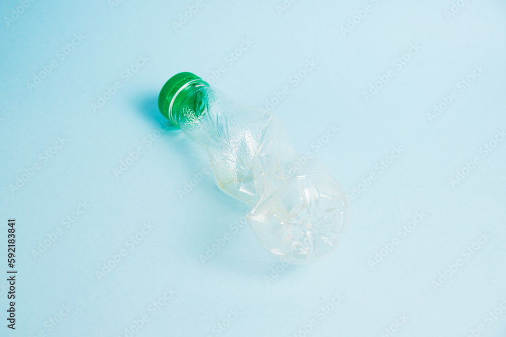 Used plastic bottle of juice for a drink on a blue background. Concept of earth day, zero waste and plastic recycling. Used plastic bottle of juice for a drink on a blue background. Concept of earth day, zero waste and plastic recycling.