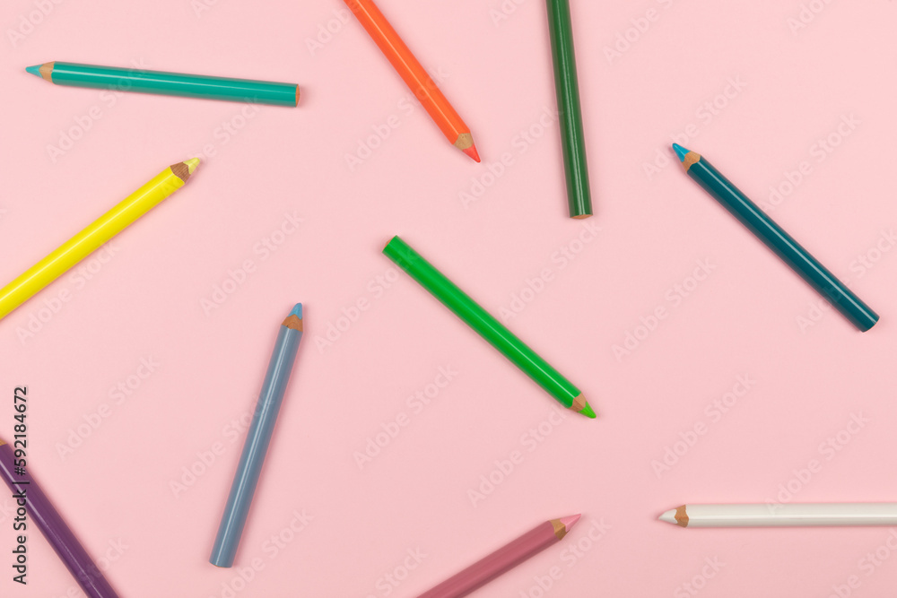 Colored pencils on the pink background. Top view. Colored pencils on the pink background. Top view.