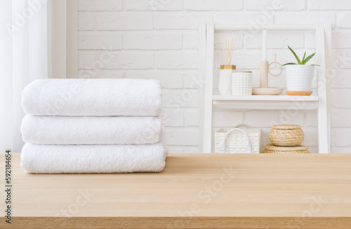 White towel stack on wooden table in bathroom with space