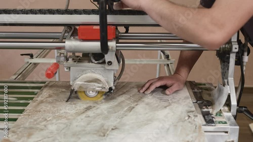 The process of cutting porcelain stoneware slabs with a hydraulic cutter. Preparation of tiles for laying on walls or floors. photo